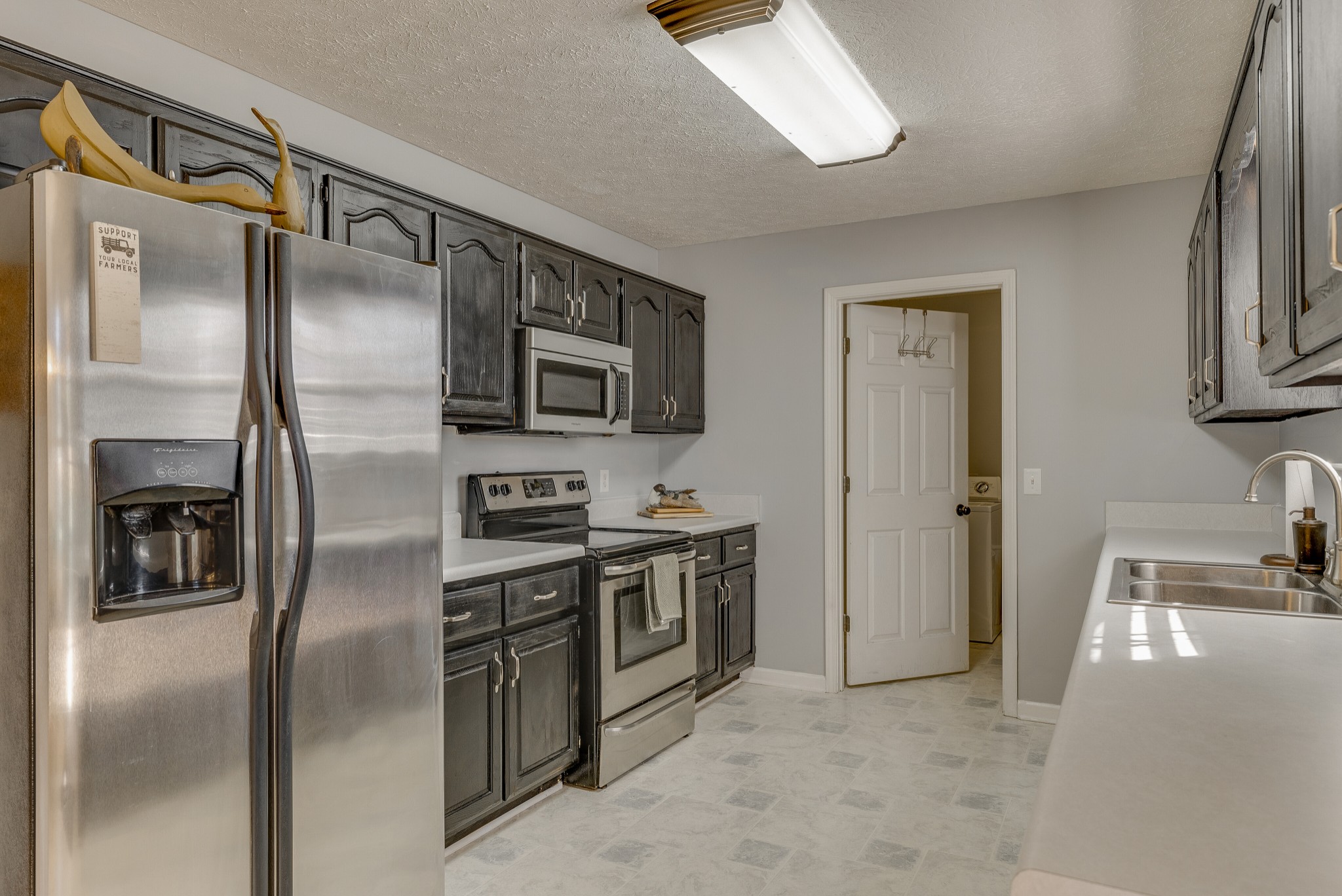 140 Cora Street Portland, TN 37148 - Photo 10 of 27 a kitchen with stainless steel appliances granite countertop a refrigerator a stove a sink and a microwave