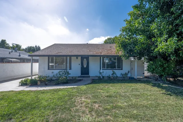a front view of a house with a garden and plants