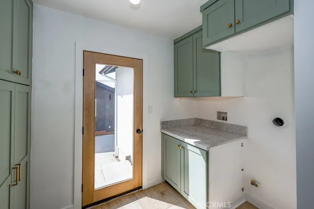 a utility room with a sink mirror and window