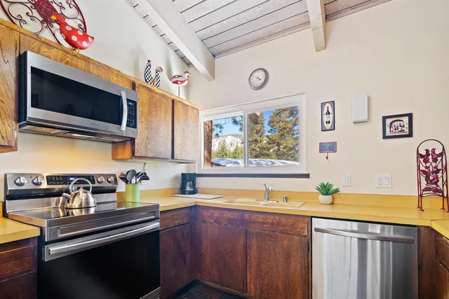 a kitchen with stainless steel appliances a stove a sink and a microwave