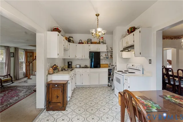a large white kitchen with cabinets