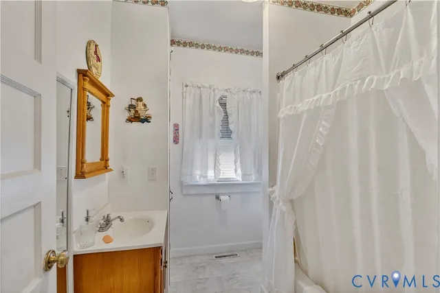 a bathroom with a shower curtain and a sink