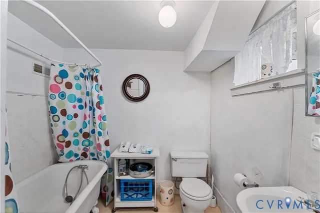 a bathroom with a toilet and a shower curtain