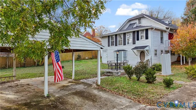 a view of a house with a yard and a wooden deck