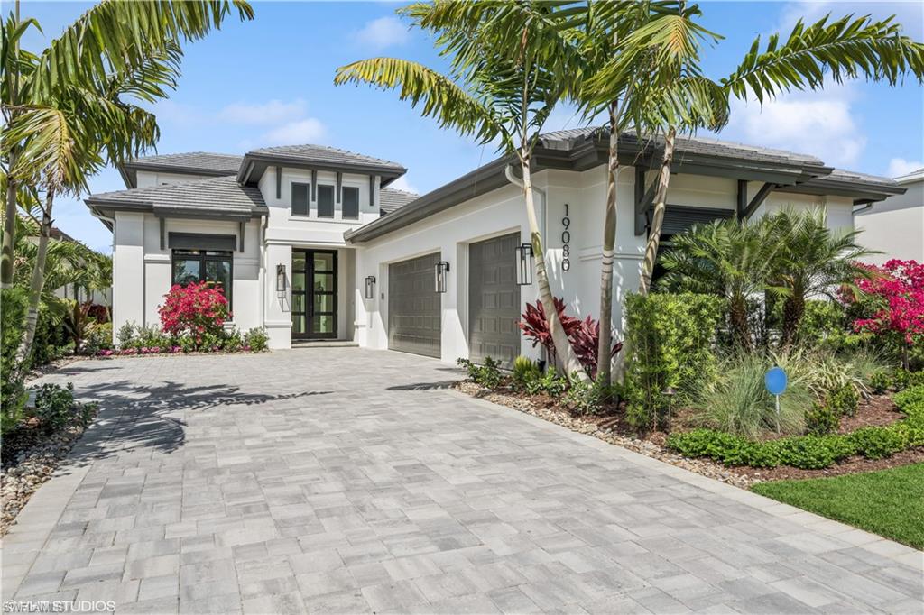 19080 Via Messina Way Miromar Lakes, FL 33913 - Photo 1 of 49 a front view of house with yard and trees around