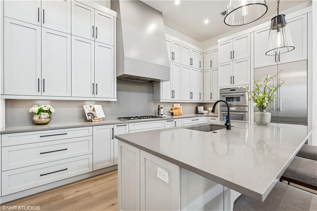 19080 Via Messina Way Miromar Lakes, FL 33913 - Photo 19 of 49 a kitchen with stainless steel appliances granite countertop a sink a stove and cabinets