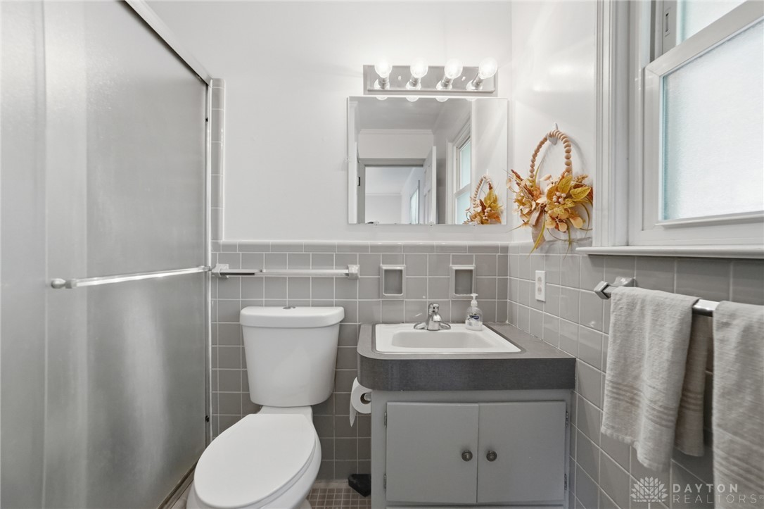 6119 Flemington Road Dayton, OH 45459 - Photo 28 of 76 This bathroom features sleek tile walls and an updated vanity, creating a refreshing atmosphere.