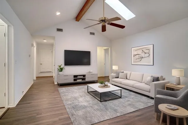 a view of a room with wooden floor fan and window