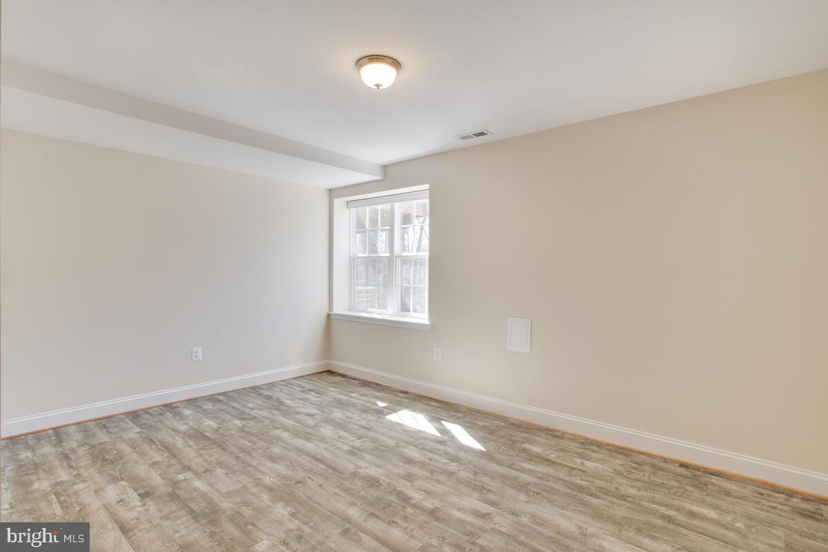 8259 Sycamore Road Lusby, MD 20657 - Photo 14 of 20 wooden floor in an empty room with a window