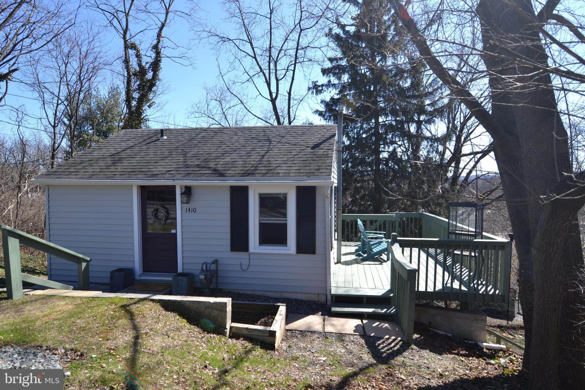 a view of house with backyard outdoor seating and covered with trees