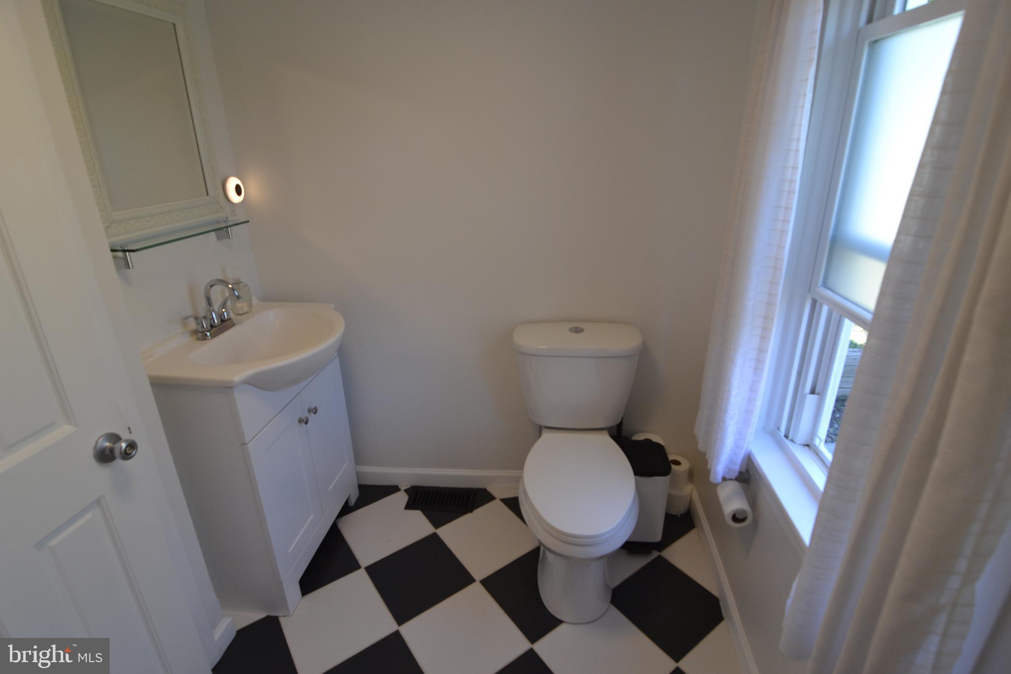 1410 West Locust Street York, PA 17404 - Photo 16 of 23 a white toilet sitting next to a sink and a mirror