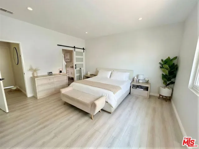 a bedroom with a bed and flat tv screen