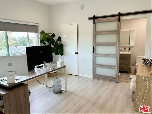a view of a workspace with furniture and a flat screen tv