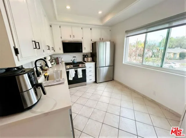 a kitchen with stainless steel appliances a refrigerator sink and microwave