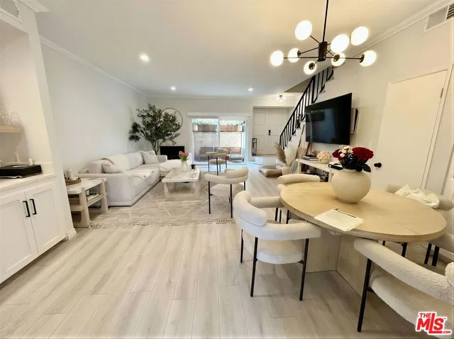 wooden floor with a couch and a large window with garden view
