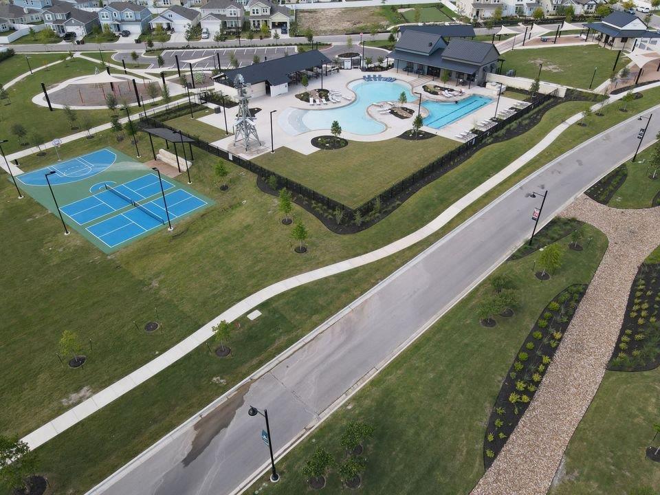 156 Huckleberry Lane Elgin, TX 78621 - Photo 14 of 16 An aerial perspective reveals a vibrant community with recreational amenities and thoughtfully designed green spaces.