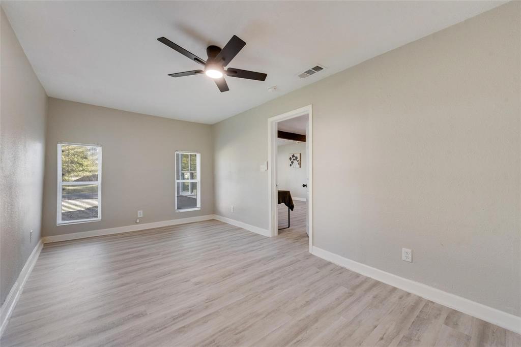 109 Lydia Street Terrell, TX 75160 - Photo 15 of 22 an empty room with wooden floor a ceiling fan and windows