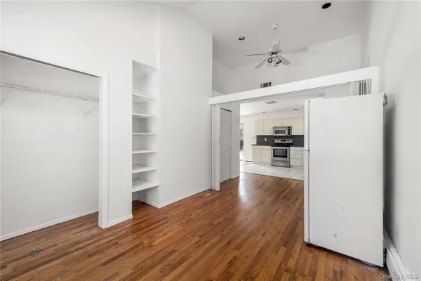 a view of a kitchen with wooden floor and a refrigerator