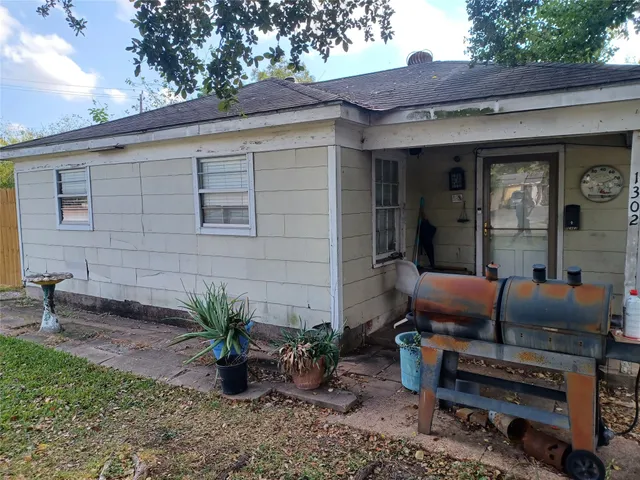 a backyard of a house with barbeque oven table and chairs