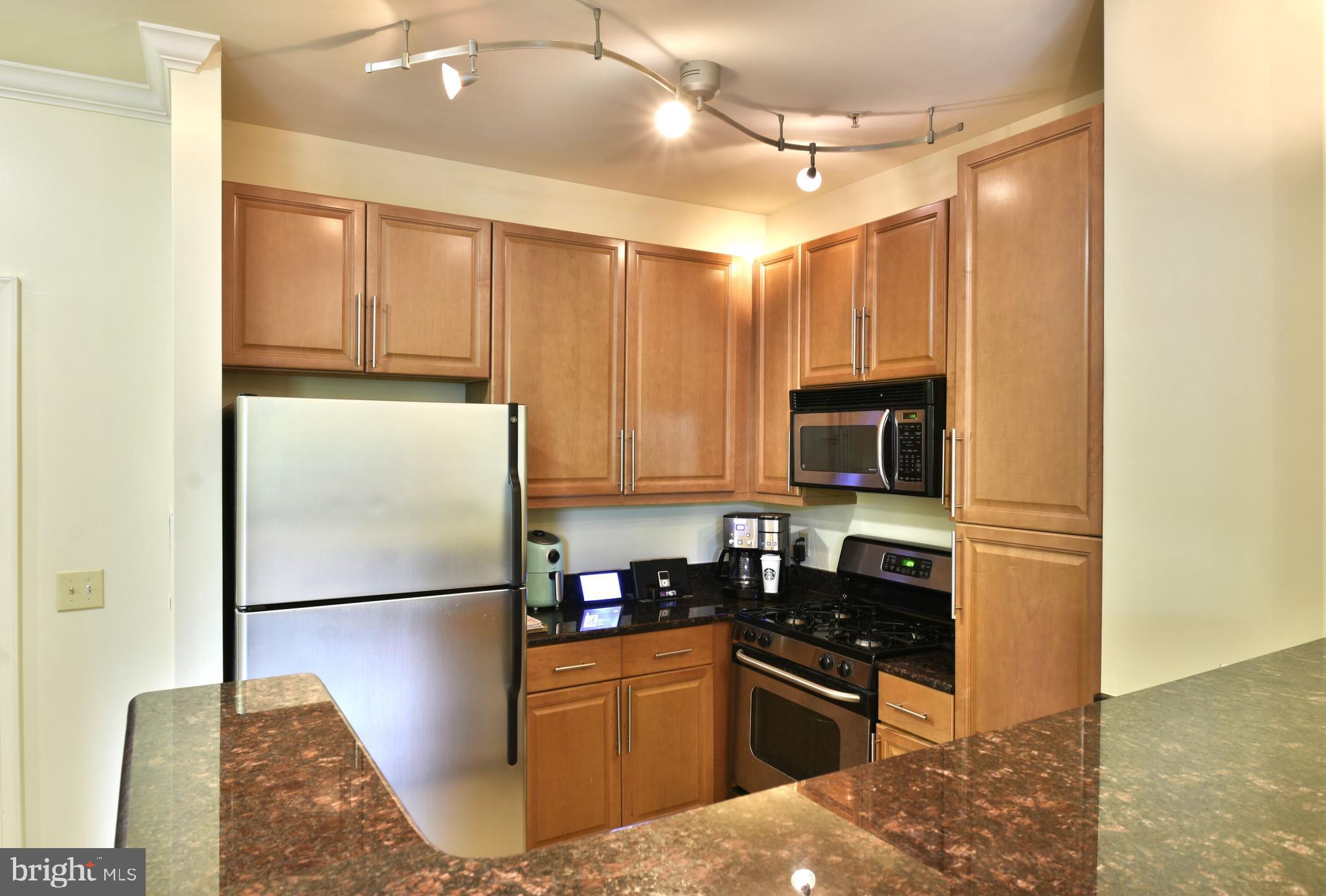 11770 Sunrise Valley Drive, Unit 120 Reston, VA 20191 - Photo 17 of 41 a kitchen with stainless steel appliances granite countertop a refrigerator a stove a sink and a microwave