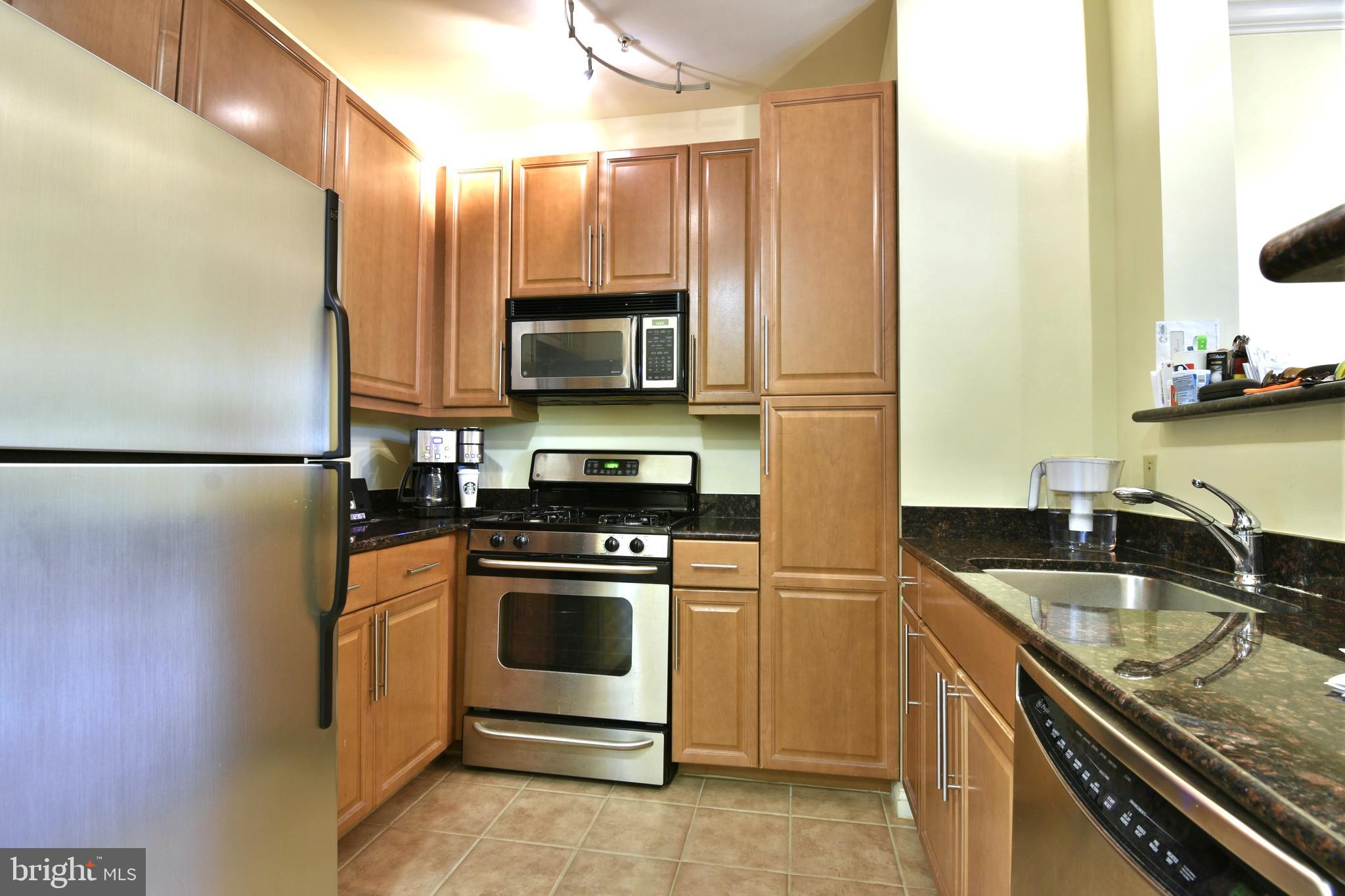 11770 Sunrise Valley Drive, Unit 120 Reston, VA 20191 - Photo 18 of 41 a kitchen with granite countertop a sink stove and refrigerator