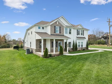 a front view of a house with a yard and porch