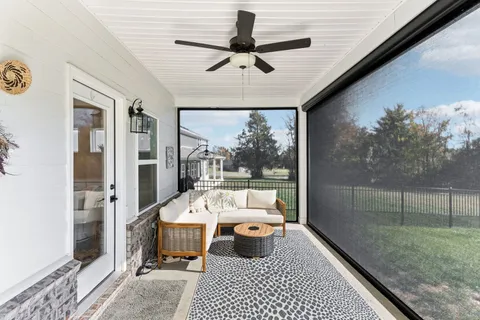 a view of a house next to a big yard and large trees