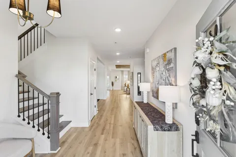 a view of a hallway with wooden floor and staircase