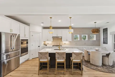 a kitchen with kitchen island granite countertop a sink stove and refrigerator