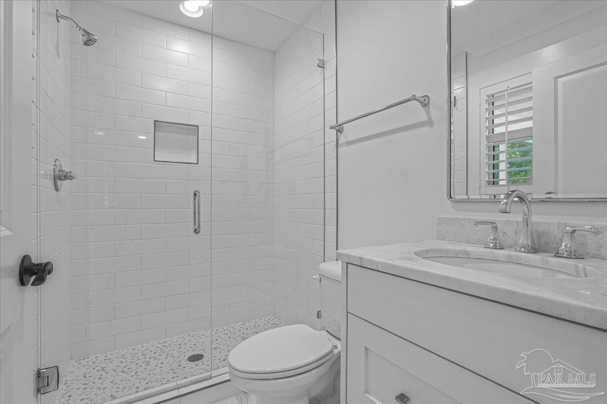 3540 Dunfries Road Pensacola, FL 32503 - Photo 37 of 48 a bathroom with a granite countertop sink toilet a mirror and shower