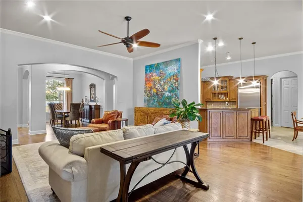 a living room with furniture a refrigerator and a flat screen tv