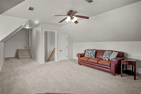 a living room with furniture and a ceiling fan
