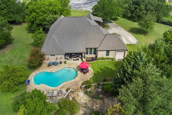 an aerial view of a house with outdoor space and swimming pool