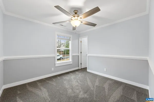 an empty room with windows and ceiling fan