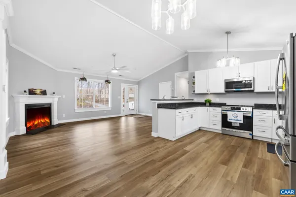 a kitchen with stainless steel appliances a stove top oven a sink a counter space and cabinets