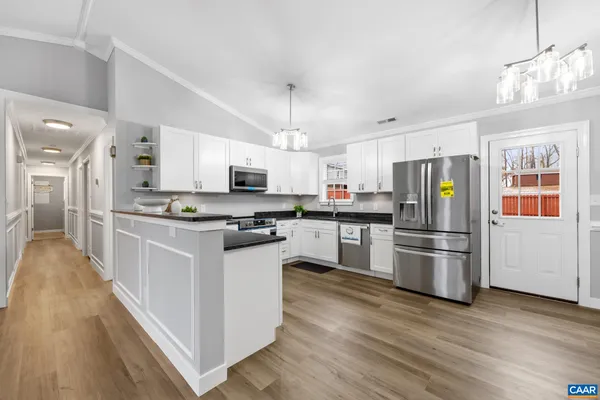 a kitchen with stainless steel appliances a refrigerator sink and microwave