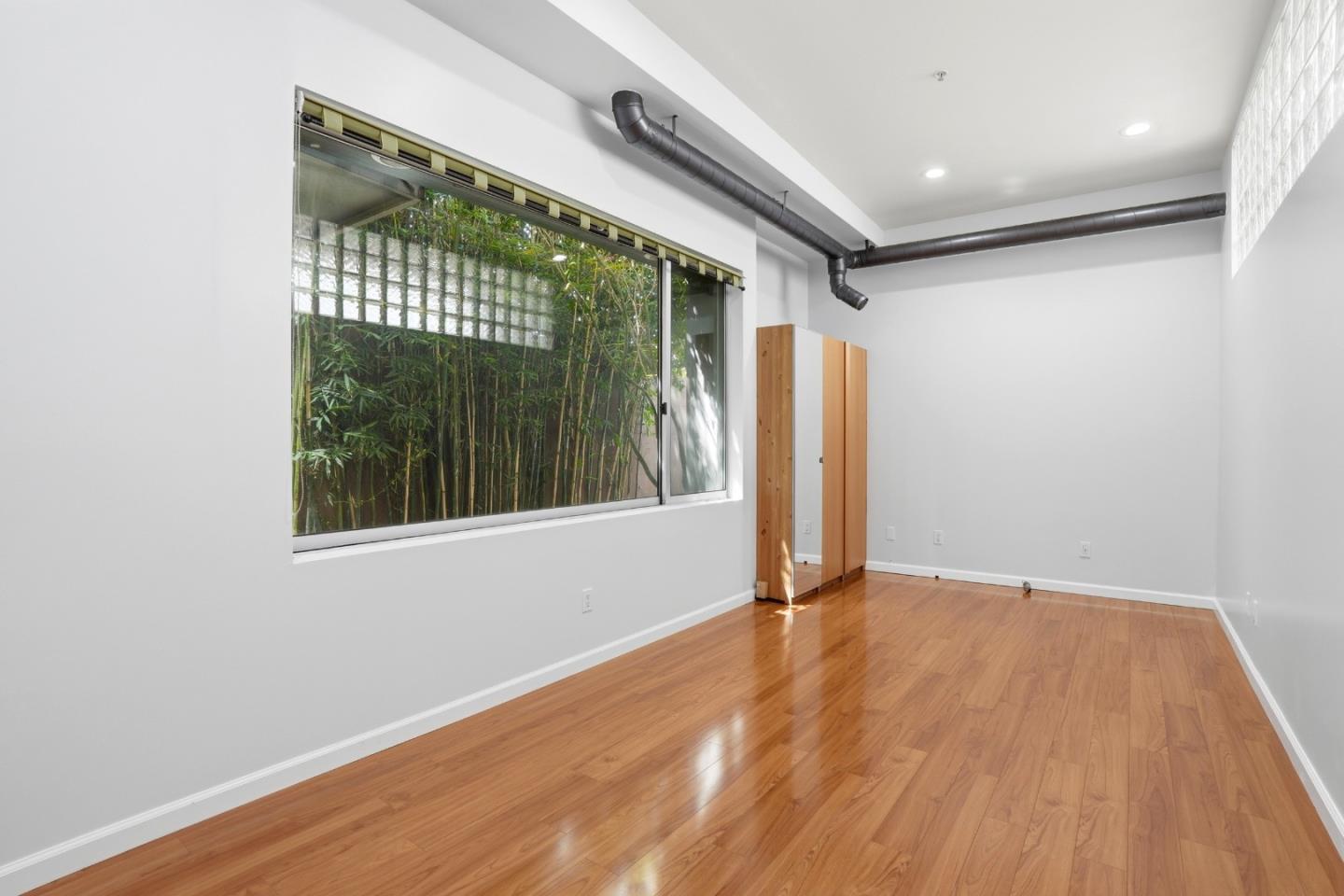 2709 Tenth Street, Unit C Berkeley, CA 94710 - Photo 12 of 44 a view of an empty room with wooden floor and a window