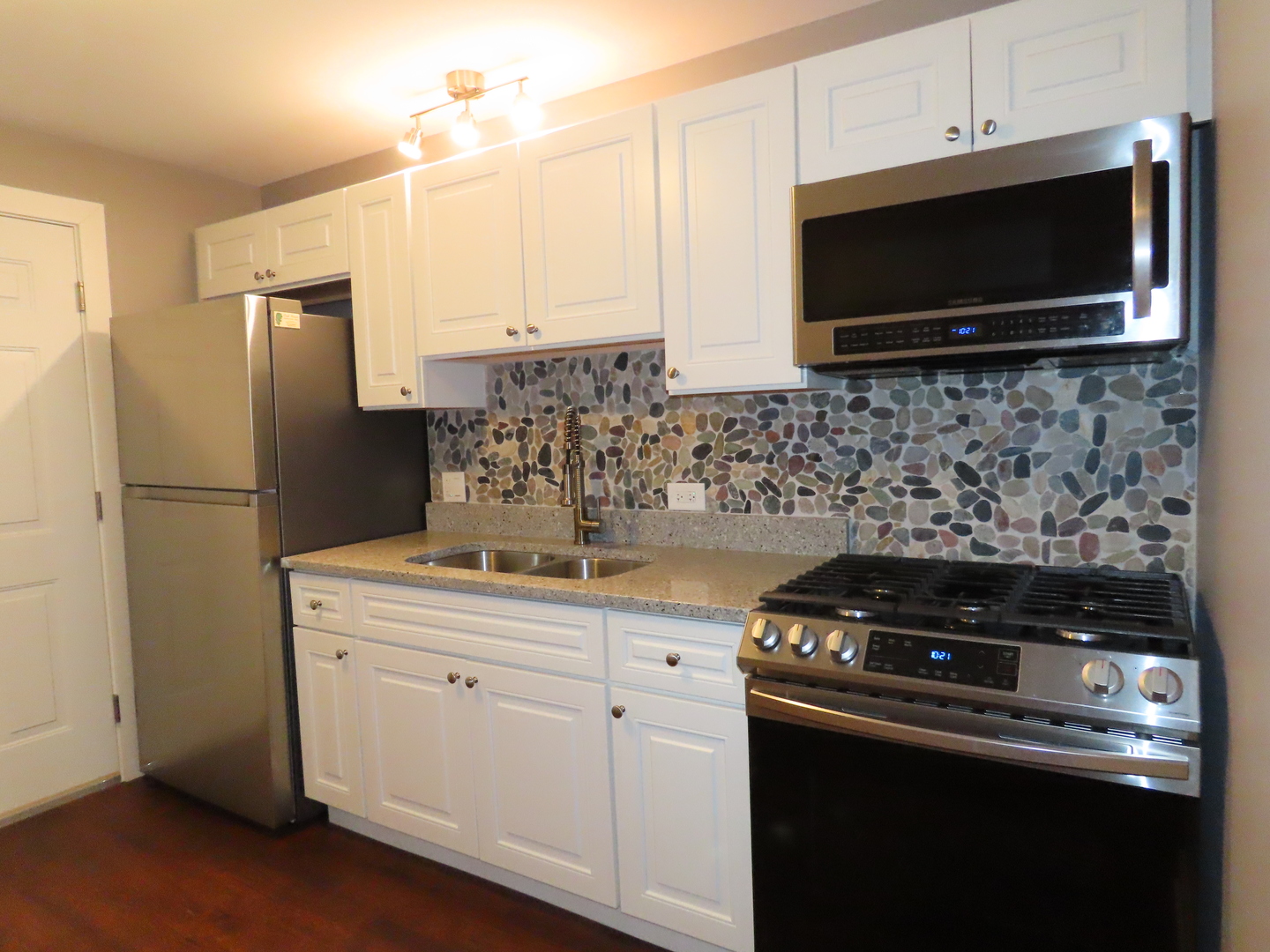14830 Ketelaar Drive, Unit 4E Midlothian, IL 60445 - Photo 6 of 23 a kitchen with stainless steel appliances a stove a microwave and a refrigerator