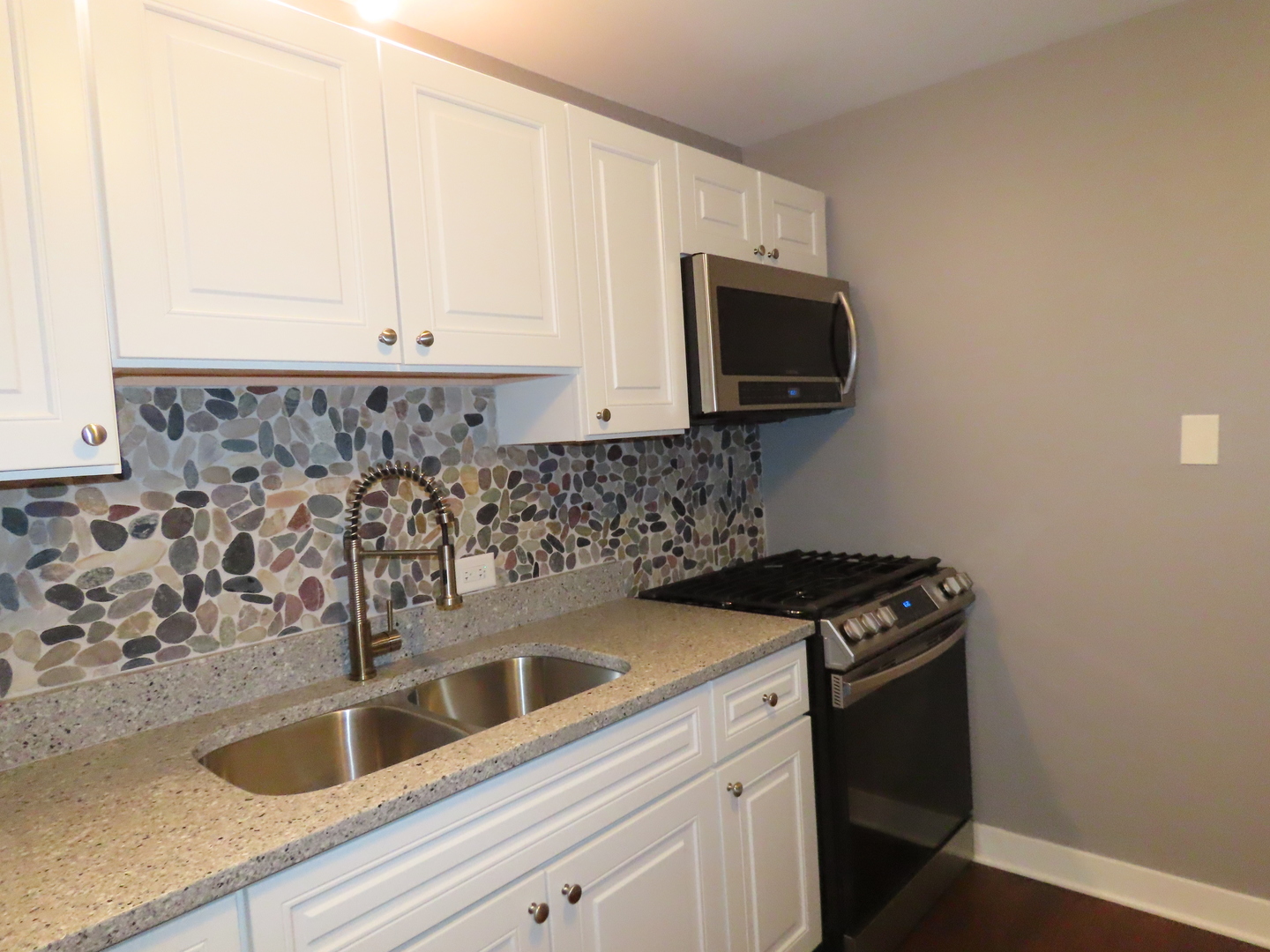 14830 Ketelaar Drive, Unit 4E Midlothian, IL 60445 - Photo 8 of 23 a kitchen with granite countertop white cabinets sink and stainless steel appliances