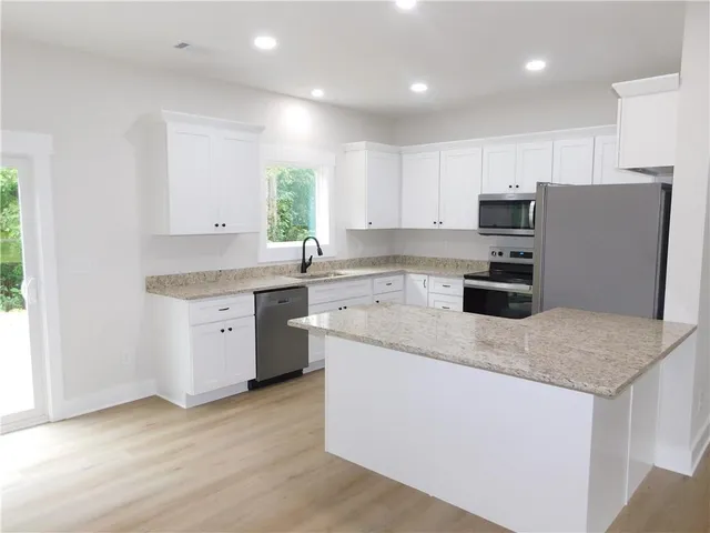 a kitchen with stainless steel appliances granite countertop a stove a sink and a refrigerator