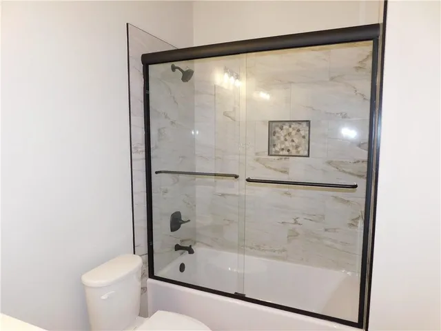 a view of empty room with ceiling fan and window