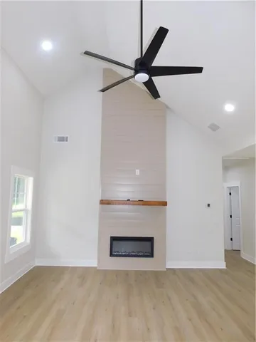 a view of an empty room with a window and a fireplace