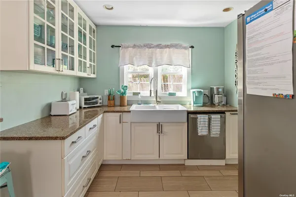 a kitchen with granite countertop a sink stove and cabinets