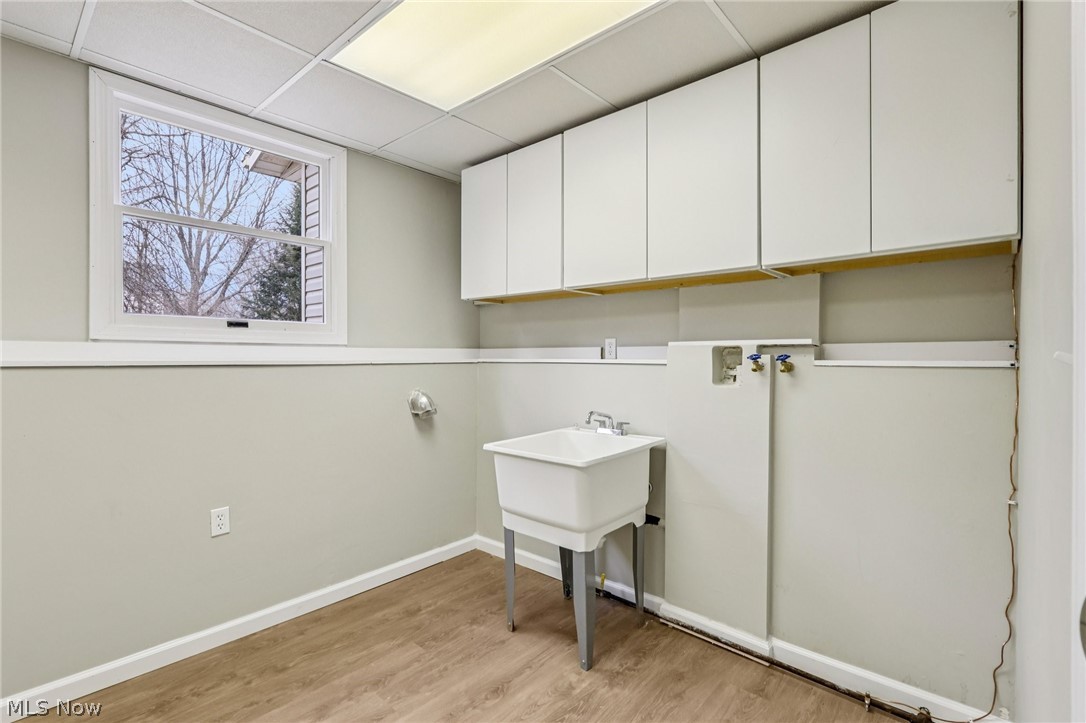 2829 Tibbetts Wick Road Hubbard, OH 44425 - Photo 25 of 44 Laundry room with cabinet space, light wood-style floors, a paneled ceiling, and hookup for a washing machine