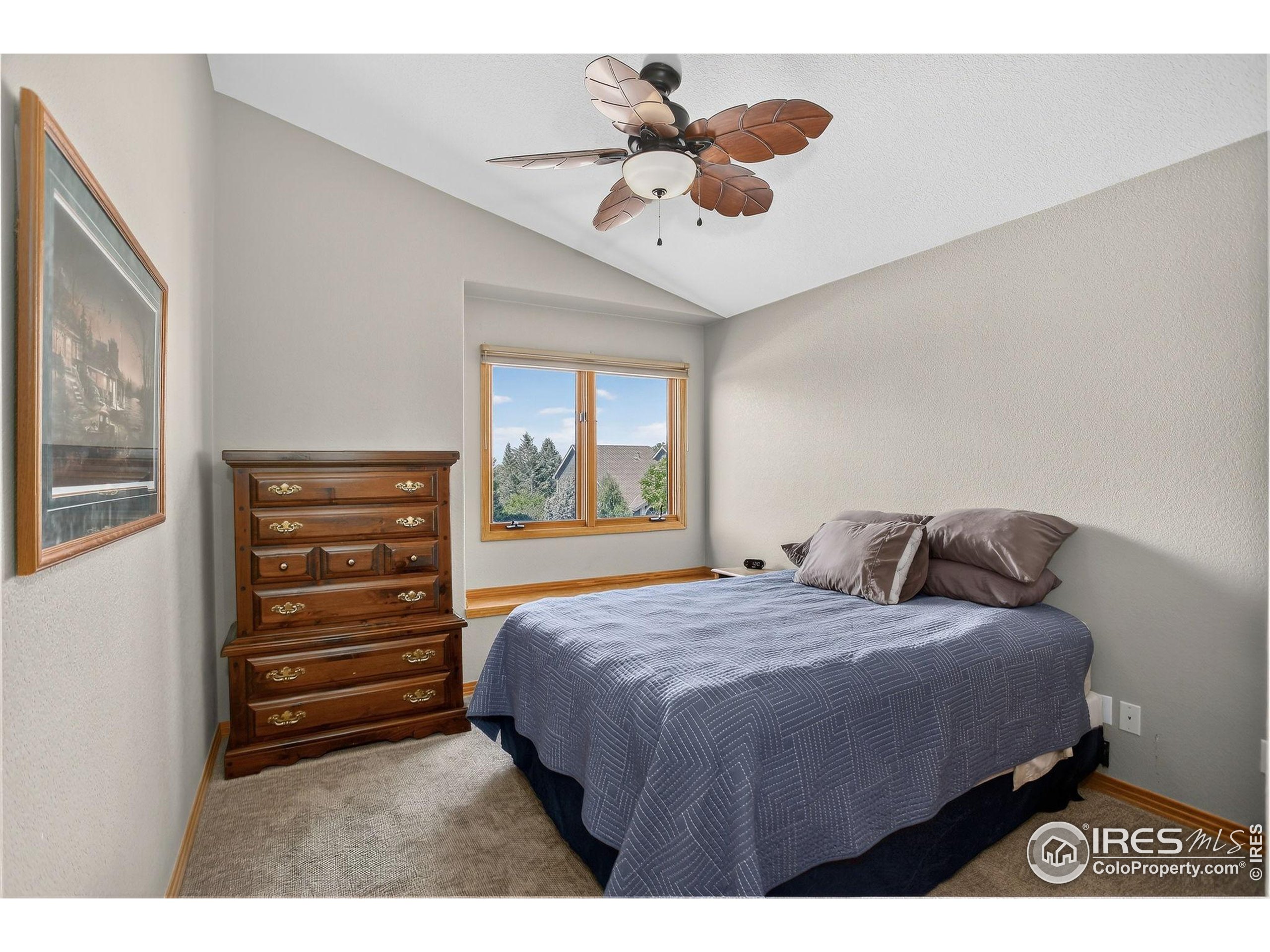 1840 Red Cloud Road Longmont, CO 80504 - Photo 22 of 42 a bedroom with a bed and a chandelier