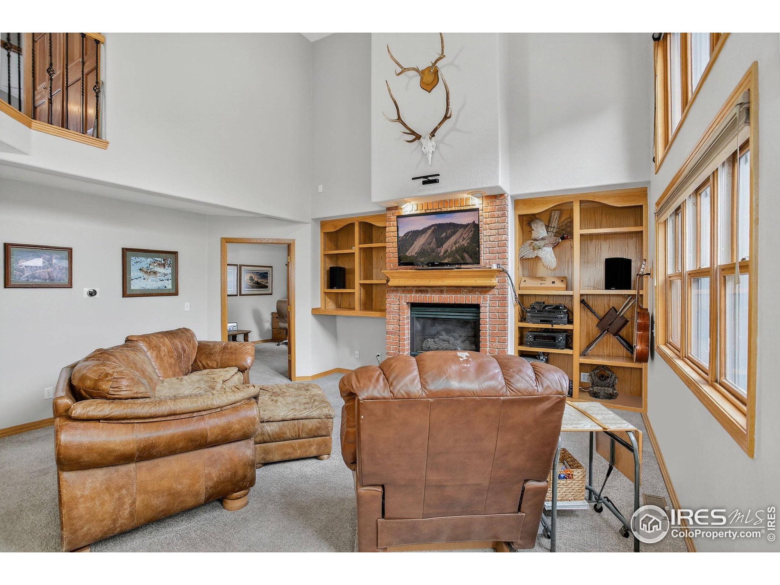 1840 Red Cloud Road Longmont, CO 80504 - Photo 6 of 42 a living room with furniture a fireplace and a flat screen tv