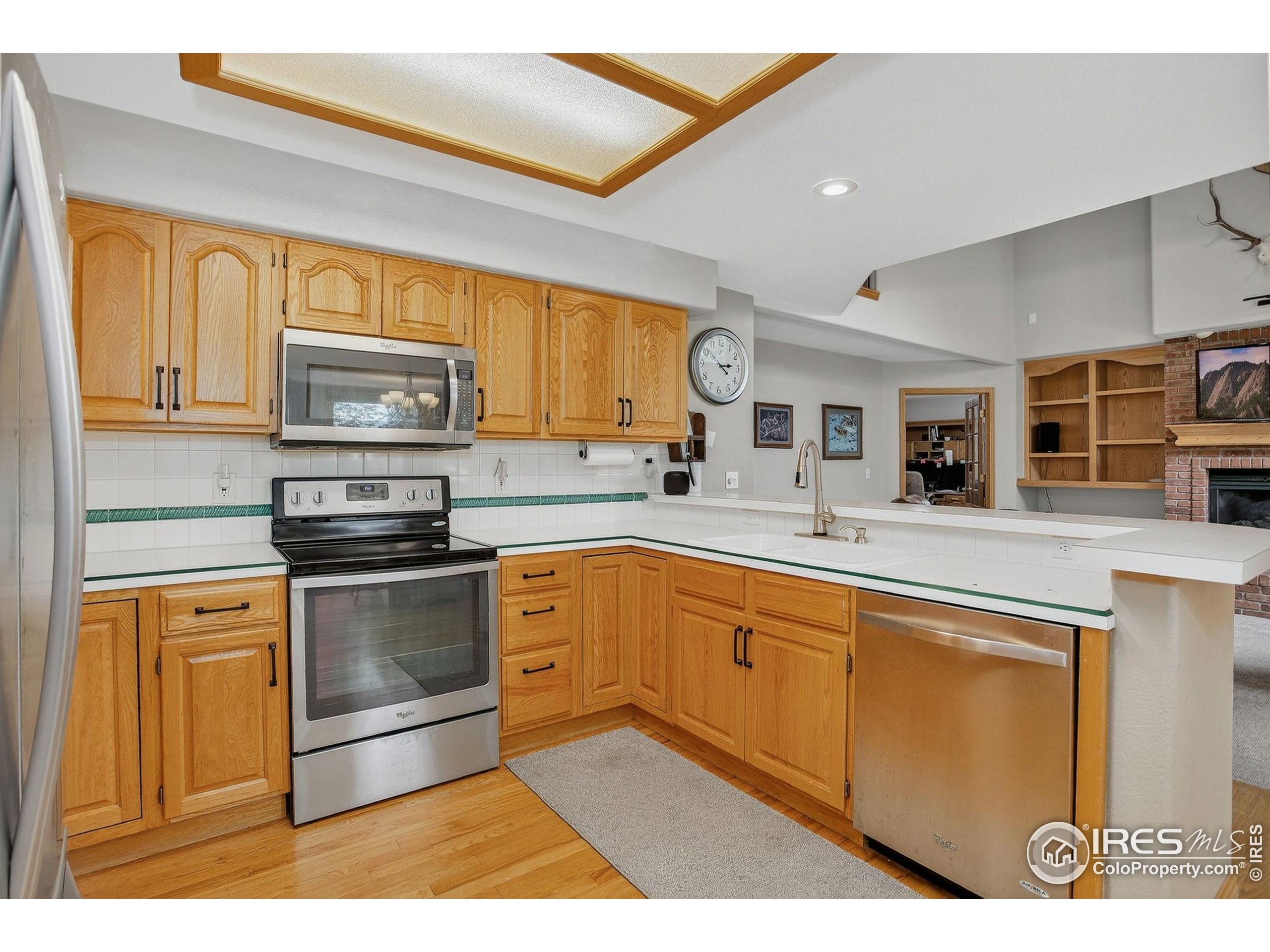 1840 Red Cloud Road Longmont, CO 80504 - Photo 7 of 42 a kitchen with stainless steel appliances granite countertop a stove a sink and a microwave