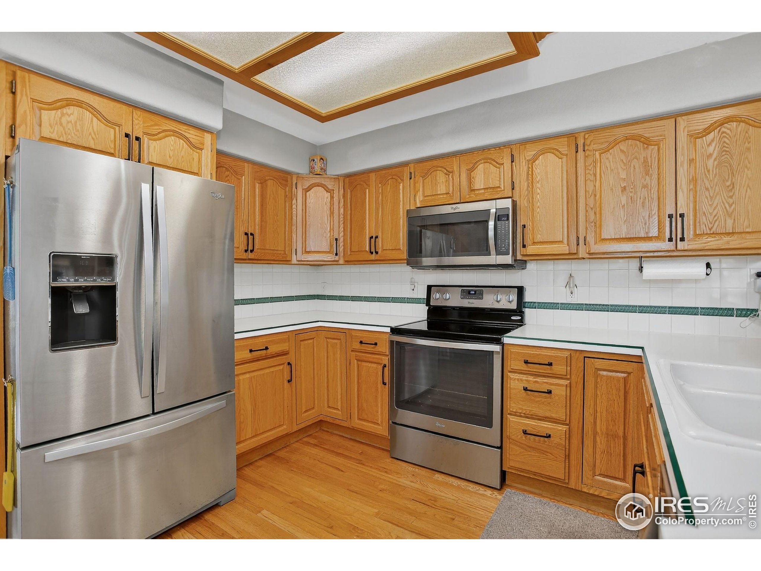 1840 Red Cloud Road Longmont, CO 80504 - Photo 8 of 42 a kitchen with granite countertop a refrigerator stove and microwave