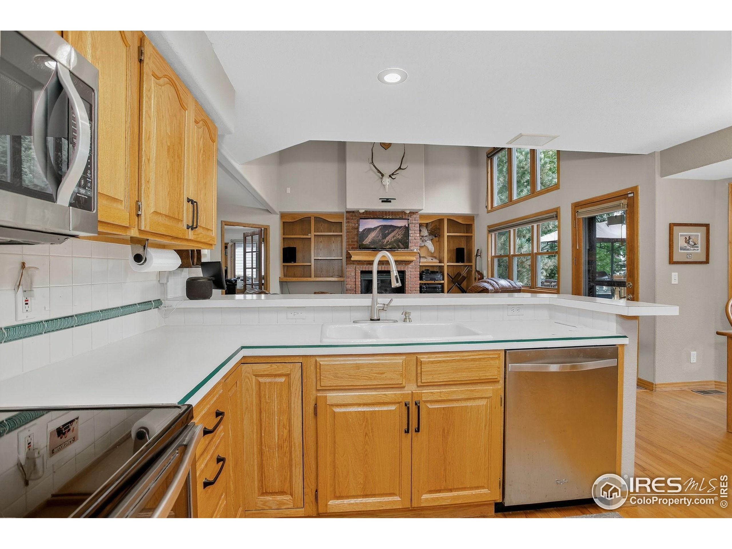 1840 Red Cloud Road Longmont, CO 80504 - Photo 10 of 42 a view of a kitchen with kitchen island a sink wooden floor and a counter top space