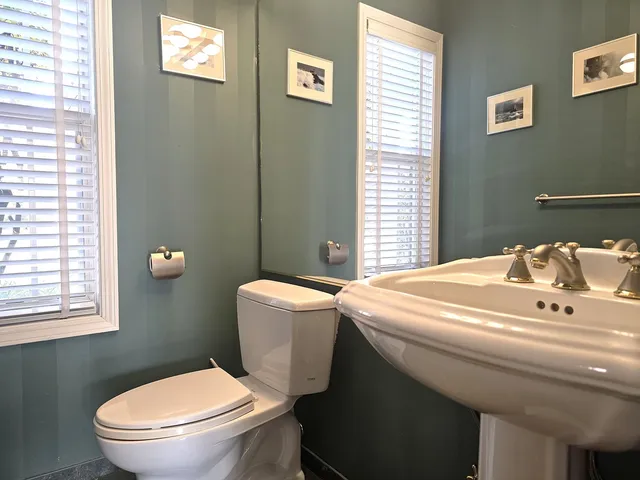 a bathroom with a sink a toilet and window